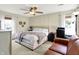 Bright bedroom featuring a ceiling fan, a large bed, and a comfy brown leather couch for relaxing at 9255 Fireside Dr, Indianapolis, IN 46250