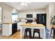 Modern kitchen features an island with seating, black appliances, and light wood countertops at 9255 Fireside Dr, Indianapolis, IN 46250