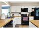 Kitchen featuring an island, black appliances, and light wood countertops at 9255 Fireside Dr, Indianapolis, IN 46250