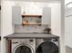 Efficient laundry area featuring a washer, dryer, cabinets, and shelving providing a organized space at 9255 Fireside Dr, Indianapolis, IN 46250