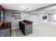 Basement wet bar area with brick accent wall, shelving, dark cabinets, and a tiled countertop at 10155 Landis Blvd, Fortville, IN 46040