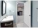 Bathroom featuring a modern vanity, a well lit mirror, and a doorway looking into a basement bar area at 10155 Landis Blvd, Fortville, IN 46040