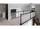 Upstairs landing with stylish black and white bannister with view to a sunlit living area and a cozy bedroom at 10155 Landis Blvd, Fortville, IN 46040