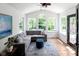 Bright living room featuring a vaulted ceiling, large windows, and a comfortable gray sectional at 10155 Landis Blvd, Fortville, IN 46040