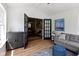 Well-lit living room showcasing black french doors and gray furnishings over wood flooring at 10155 Landis Blvd, Fortville, IN 46040