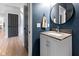 Half bath with blue walls, round mirror and a gray vanity with modern fixtures at 10155 Landis Blvd, Fortville, IN 46040