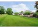 Spacious backyard featuring lush green grass, mature trees, and a relaxing deck at 10833 Tournament Ln, Indianapolis, IN 46229