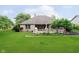 Well-maintained backyard with a wooden deck, lush lawn, and mature trees at 10833 Tournament Ln, Indianapolis, IN 46229