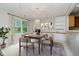 Dining room with a wooden table, built-in cabinets, and a large window overlooking the backyard at 10833 Tournament Ln, Indianapolis, IN 46229