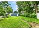 Backyard featuring a well-maintained lawn, leading to a detached garage at 1115 N Keystone Ave, Indianapolis, IN 46201