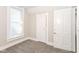 Bedroom featuring neutral paint, gray carpet, a bright window, and white doors at 1115 N Keystone Ave, Indianapolis, IN 46201