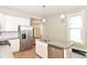 The open-concept kitchen features modern appliances, white cabinets, and a view into the adjacent living area at 1115 N Keystone Ave, Indianapolis, IN 46201