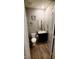 A bathroom with wood floor, black cabinet, white toilet, and white door at 11204 Sashing Way, Monrovia, IN 46157