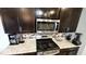 This is a kitchen with granite counters, stainless steel microwave, and dark cabinets at 11204 Sashing Way, Monrovia, IN 46157