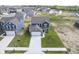 An aerial shot shows a two-story home with a grey roof, a long driveway, and green grass at 1181 Galaxy Ln, Danville, IN 46122