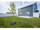 Wide backyard features green lawn, patio, white fence, and a young tree at 1181 Galaxy Ln, Danville, IN 46122