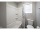 Well-lit bathroom features a white bathtub, shower, and toilet under a window with blinds at 1181 Galaxy Ln, Danville, IN 46122