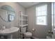 Cozy powder room with a pedestal sink, round mirror, and neutral decor for a clean and simple look at 1181 Galaxy Ln, Danville, IN 46122