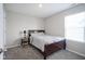 Cozy bedroom features soft carpet, a side table, and a window with blinds for natural light at 1181 Galaxy Ln, Danville, IN 46122