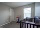 Bright bedroom with a small crib, a basketball hoop, and gray carpet at 1181 Galaxy Ln, Danville, IN 46122