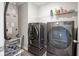 Functional laundry room equipped with gray front load washer and dryer on risers at 1181 Galaxy Ln, Danville, IN 46122