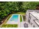 Aerial view of a modern home with pool, patio, and surrounded by lush forest at 11911 Eden Glen Dr, Carmel, IN 46033