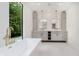 Modern bathroom featuring double vanity, standalone tub, and scenic view at 11911 Eden Glen Dr, Carmel, IN 46033