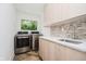 Functional laundry room with modern appliances, quartz countertops, and stylish backsplash at 11911 Eden Glen Dr, Carmel, IN 46033