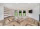 Bright living room featuring large windows overlooking the front yard, modern lighting and built in shelving at 11911 Eden Glen Dr, Carmel, IN 46033