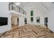 Bright living room with high ceilings, herringbone floors, and a modern staircase at 11911 Eden Glen Dr, Carmel, IN 46033