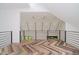 Upstairs loft area featuring herringbone floors and a modern railing with a view of the main living area at 11911 Eden Glen Dr, Carmel, IN 46033