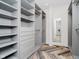 Large walk-in closet with custom gray shelving and drawers complemented by herringbone flooring at 11911 Eden Glen Dr, Carmel, IN 46033