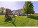 Large backyard with a play structure, lush green grass and a patio area by the house at 1238 Aggie Ln, Indianapolis, IN 46260