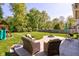 A well-manicured backyard includes a concrete patio area with furniture and a fire pit at 1238 Aggie Ln, Indianapolis, IN 46260