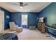 Bedroom with ceiling fan, chair and ottoman, and mounted TV over shelving at 1238 Aggie Ln, Indianapolis, IN 46260