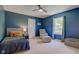 Comfortable bedroom features a ceiling fan, armchair, and a large sunlit window at 1238 Aggie Ln, Indianapolis, IN 46260