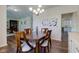 Dining area with dark wood table, seating for four, hardwood floors, and a view of living spaces and artwork at 1238 Aggie Ln, Indianapolis, IN 46260