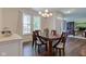 Dining room featuring a wood table with seating for six, hardwood floors, and natural light from the window at 1238 Aggie Ln, Indianapolis, IN 46260