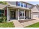 Inviting front porch with brick columns, red shutters, and landscaping with walkway leading to the main entrance at 1238 Aggie Ln, Indianapolis, IN 46260