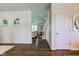 Bright hallway featuring hardwood floors, white walls, and views into the living area and staircase at 1238 Aggie Ln, Indianapolis, IN 46260
