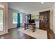 Bright home office with hardwood floors, decorative cabinets, a large window, and a desk with office chair at 1238 Aggie Ln, Indianapolis, IN 46260