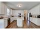 Kitchen with stainless appliances, island, white cabinets, and hardwood floors at 1238 Aggie Ln, Indianapolis, IN 46260