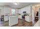 Kitchen features stainless steel appliances, island, white cabinets and hardwood floors at 1238 Aggie Ln, Indianapolis, IN 46260