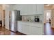 Bright kitchen with stainless steel refrigerator, white cabinets and hardwood floors at 1238 Aggie Ln, Indianapolis, IN 46260