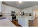 Bright kitchen with stainless steel appliances, island, white cabinets and hardwood floors at 1238 Aggie Ln, Indianapolis, IN 46260