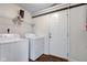 Practical laundry room featuring washer, dryer, and access door with shelving for storage at 1238 Aggie Ln, Indianapolis, IN 46260