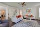 Bright living room with hardwood floors, neutral-toned sofas, a ceiling fan, and a view of the staircase at 1238 Aggie Ln, Indianapolis, IN 46260