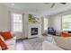 Cozy living room with a fireplace, a TV mounted above the mantel, hardwood floors, and comfortable seating at 1238 Aggie Ln, Indianapolis, IN 46260