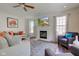 Inviting living room with fireplace, ceiling fan, and lots of natural light from multiple windows at 1238 Aggie Ln, Indianapolis, IN 46260