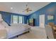 Main bedroom with blue accent wall, sitting area and ceiling fan with large window at 1238 Aggie Ln, Indianapolis, IN 46260